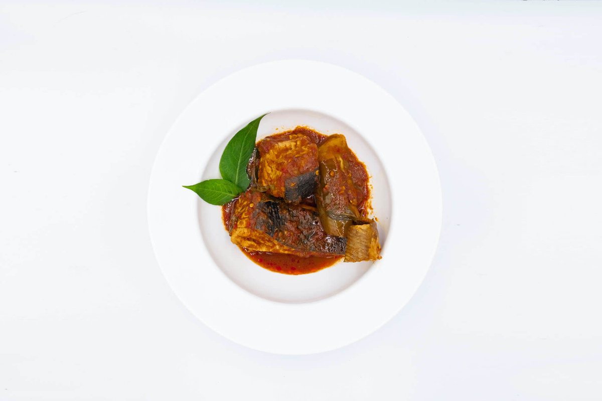 Asam pedas fish in red sauce photographed from above in a white bowl